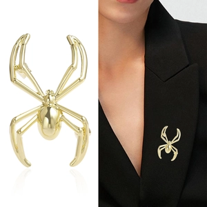 Polished golden spider brooch for men shown on white background and black suit lapel
