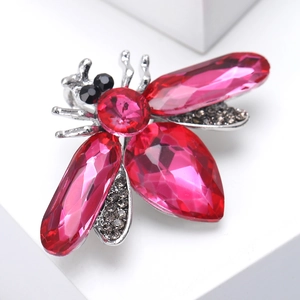 Macro shot of bee lapel pin with pink crystals and grey diamonds on a white base