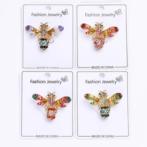 Lot de quatre broches abeilles en cristal coloré violet, rouge, rose et vert sur cartes