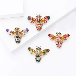 Lot de quatre broches abeille en émail coloré avec strass sur des supports géométriques