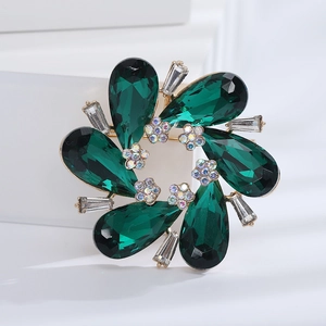 Detailed macro view of an emerald crystal floral brooch with vibrant aurora rhinestones