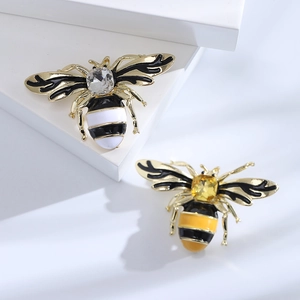 Golden bee brooches with enamel stripes and sparkling crystal accents on a display