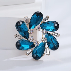 Macro shot of blue crystal floral brooch with pear-shaped stones and gold setting