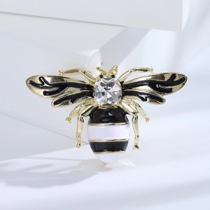 Detailed shot of a honey bee brooch with golden alloy and crystal inlay on a white pedestal