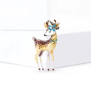 Élégante broche cerf sika avec fleur bleue et strass étincelants sur un présentoir blanc