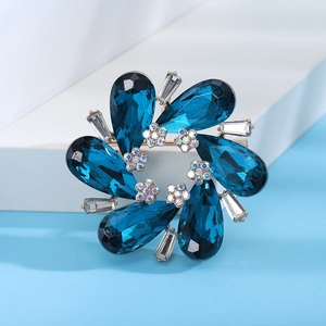 Detail of crystal floral brooch with blue teardrop stones and sparkling gems