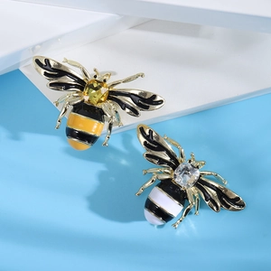 Detailed macro view of enamel bee brooches with yellow and clear crystal square stones