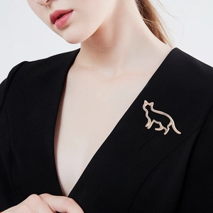 Broche chat minimaliste en or rose poli sur une veste de costume noire à col en V
