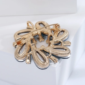 Close-up of golden crystal wreath brooch showing the secure safety pin back closure