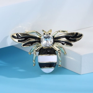 Close-up of alloy bee brooch with black and white enamel and a large faceted crystal inlay