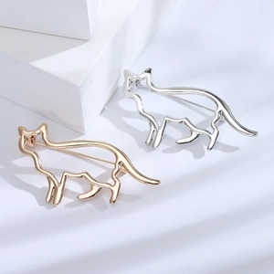 Broches silhouette chat minimalistes en métal doré et argenté sur fond blanc épuré