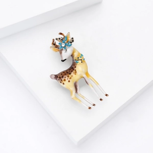 Charmante broche cerf sika en émail avec fleur bleue et cristal sur socle blanc
