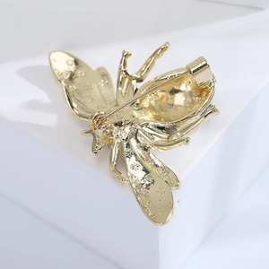Macro shot of bee brooch back detail showing metal texture and pin fastener mechanism