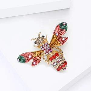Détail d'une broche abeille avec des ailes en émail coloré et des strass étincelants