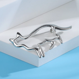 Détail d'une broche chat argentée au design ajouré avec une finition polie miroir