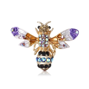 Broche abeille en cristal avec ailes émaillées colorées sur surface blanche réfléchissante