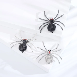 Détail des broches araignées en alliage avec strass en finitions noir et argenté