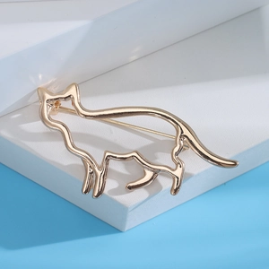 Vue détaillée de la broche silhouette de chat dorée sur un bloc géométrique moderne