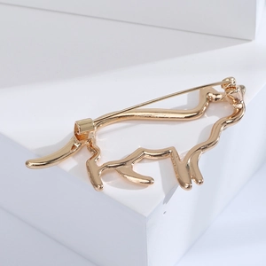 Détail du fermoir de sécurité de la broche dorée en forme de chat sur fond blanc