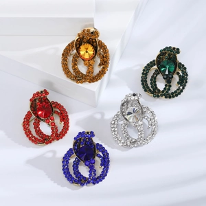 Detailed macro view showing a collection of cobra brooches in five vibrant crystal colors