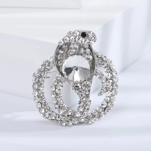 Detailed close-up of a silver snake brooch with sparkling rhinestones and a large center crystal