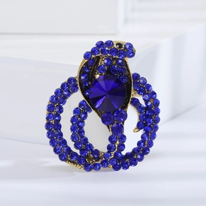 Close-up of golden snake brooch with dark blue rhinestones and large round blue gemstone