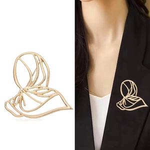 Abstract hollow butterfly gold brooch and model showcase on black suit jacket