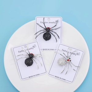 Détails macro de broches d'araignée en strass, finitions noir et argent sur carte