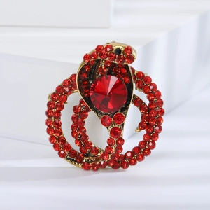 Macro detail of cobra brooch featuring red crystals and sparkling rhinestones on gold base