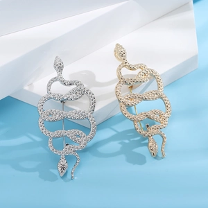 Close-up of gold and silver snake brooches with detailed scale textures on display stands