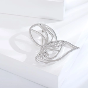 Detailed view of hollow wing brooch in silver finish with secure pin backing design