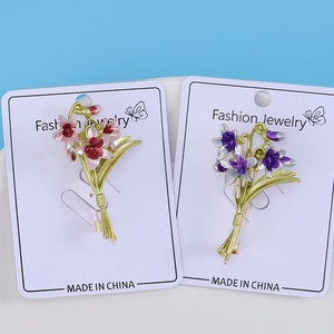 Close-up of elegant enamel orchid brooches in pink and violet showing detailed petal texture