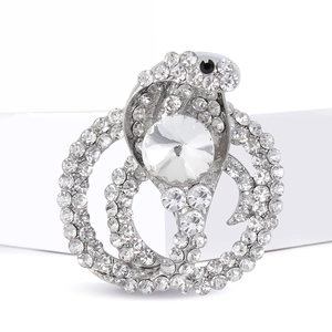 Silver snake brooch with sparkling crystals and large round center diamond on white strap