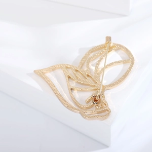 Detailed back view of gold butterfly brooch showing secure safety pin and texture
