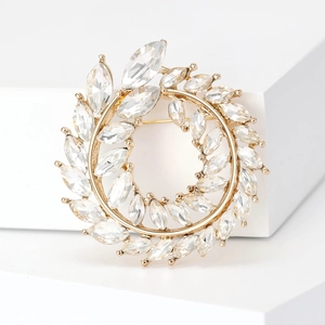 Vue détaillée d'une broche couronne d'olivier dorée avec marquises sur fond blanc
