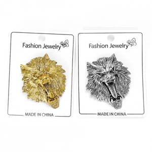 Close-up of roaring wolf head relief brooches in gold and antique silver finish