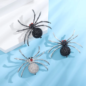 Lot de broches araignée avec strass brillants et yeux rouges sur support bleu