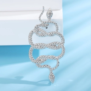 Silver vintage snake brooch featuring intricate scale texture on a light blue background