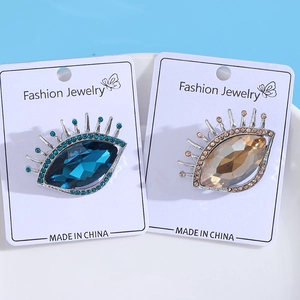 Vue détaillée de broches luxueuses en forme d'œil avec cristaux bleus et champagne