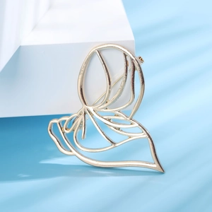 Elegant gold hollow butterfly brooch with creative minimalist outline on artistic stand