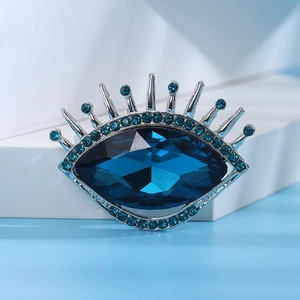 Détail de la broche œil avec pierre précieuse bleu marine et cils en strass