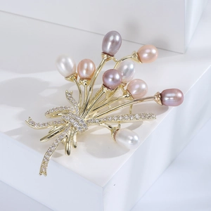 Broche bouquet en or et perles élégantes roses et blanches sur fond blanc