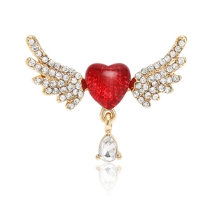 Detailed view of a gold-plated heart brooch with angel wings and a teardrop crystal