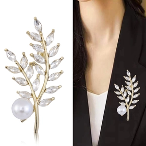 Elegante spilla a spiga di grano dorata con cristalli marquise e perla su blazer nero