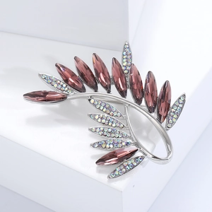 Close-up of olive branch brooch with purple crystals and colorful rhinestones
