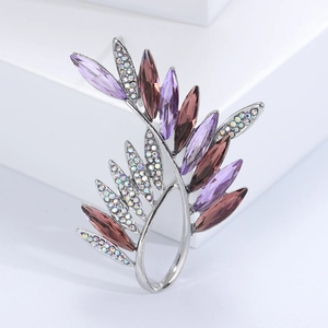 Detail of elegant olive branch brooch with purple crystals and colorful rhinestones