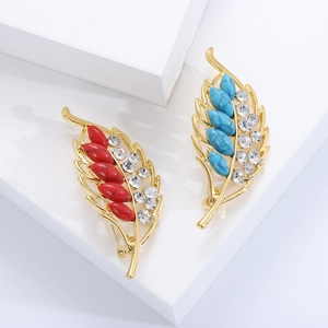 Elegant gold leaf brooches with turquoise and red stone insets and sparkling crystals