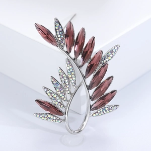 Detailed macro of olive leaf brooch with purple crystals and sparkling rainbow rhinestones
