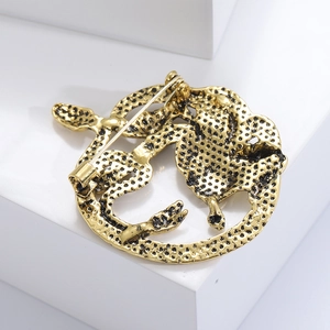 Détail du dos d'une broche Méduse vintage avec épingle de sûreté et fini texturé