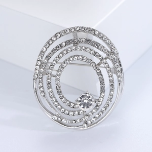 Gros plan sur une broche spirale argentée ornée de strass étincelants au design tourbillon
